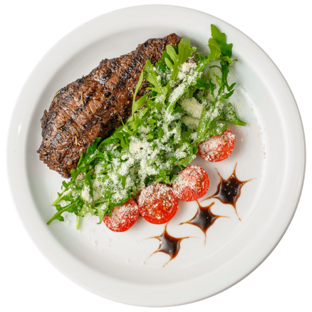 Стейк з телятини з руколою і помідорами чері